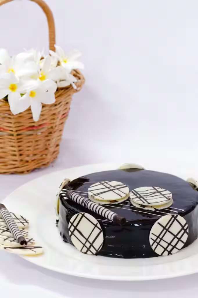 Dark chocolate celebration cake finished with white flowers
