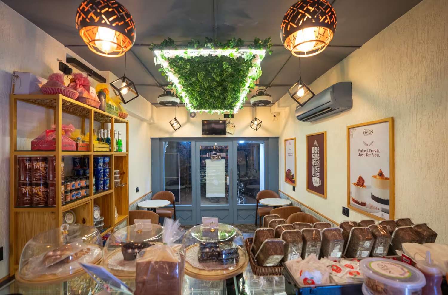 The OVEN cafe room, warm lighting, greenery and pendant lights